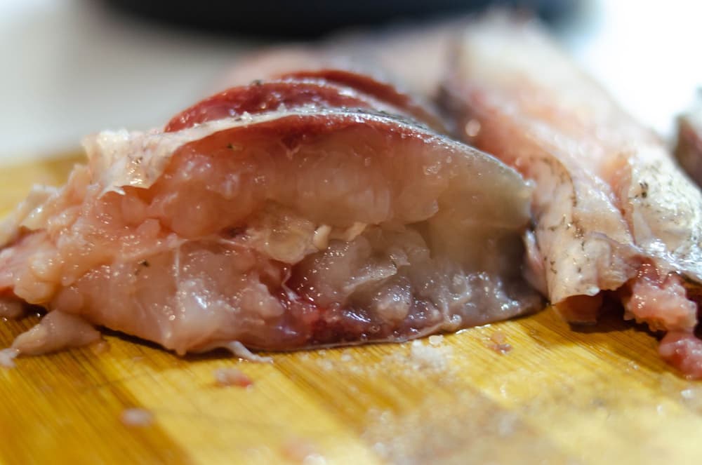 kawałek ryby leżący na desce do krojenia