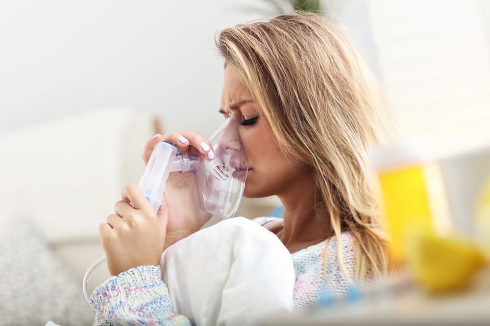 Młoda kobieta podczas inhalacji lekiem ectodose.