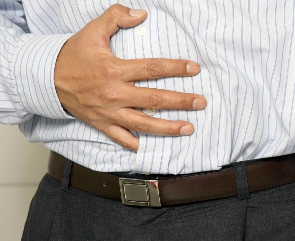 Mężczyzna trzymający się za brzuch