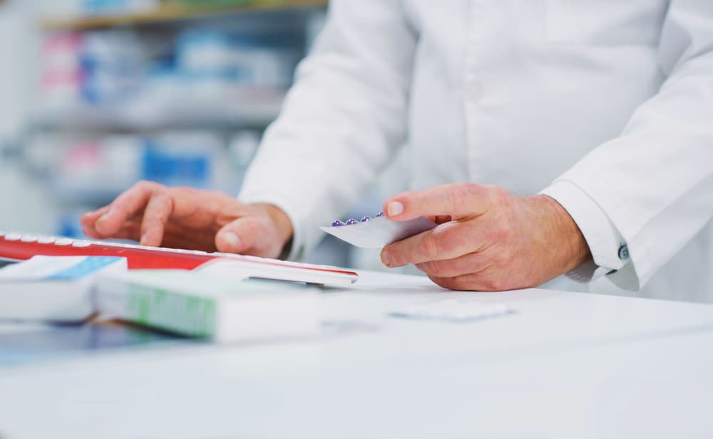 farmaceuta sprawdzający receptę w aptece