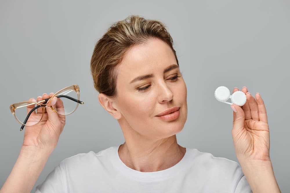 kobieta trzymająca w jednej ręce soczewki, a w drugiej okulary 