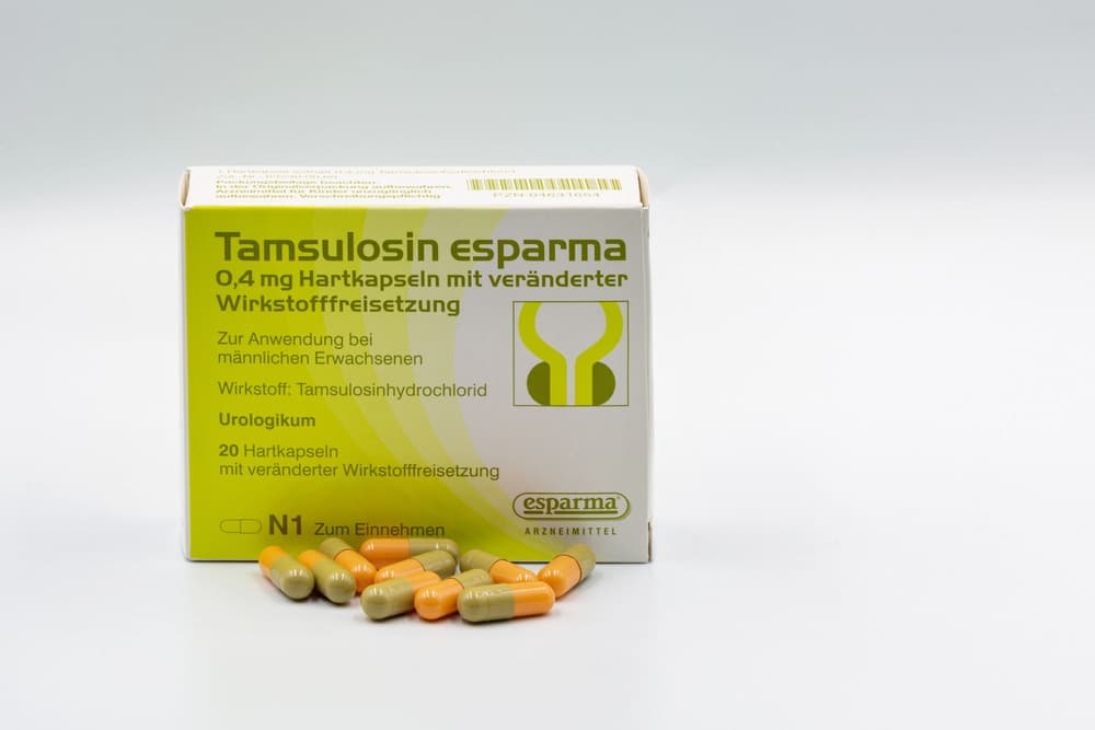 Pudełko tamsulozyny z tabletkami pomarańczowo-zielonymi obok