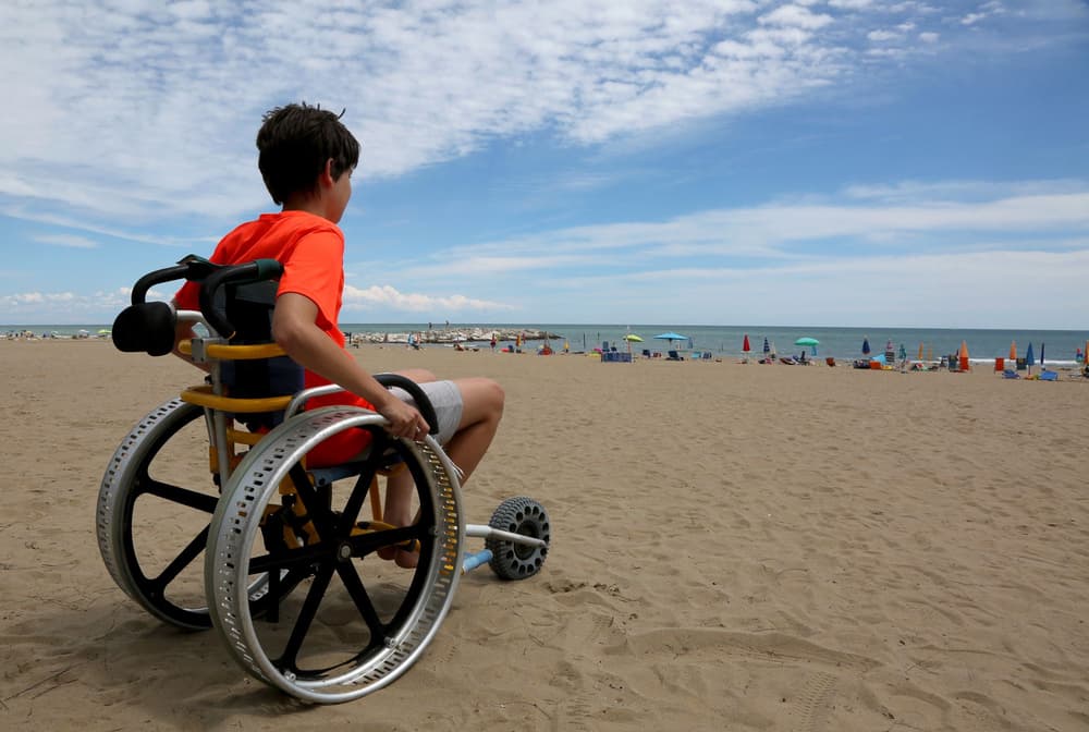 chłopiec na wózku inwalidzkim na plaży chłopiec na wózku inwalidzkim na plaży