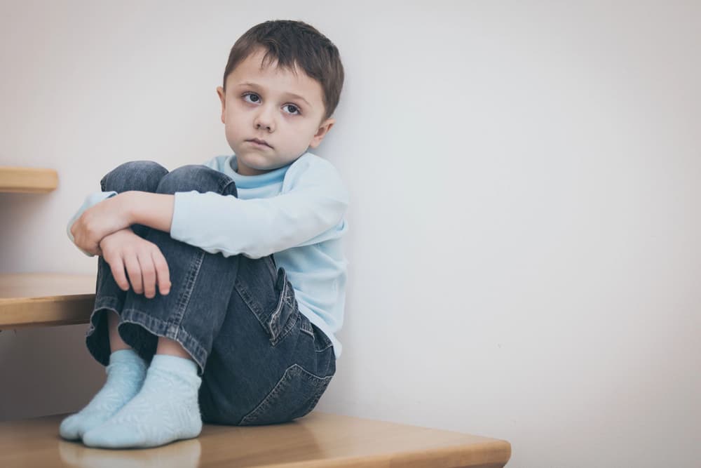 smutny chłopczyk siedzący na schodach w domu smutny chłopczyk siedzący na schodach w domu