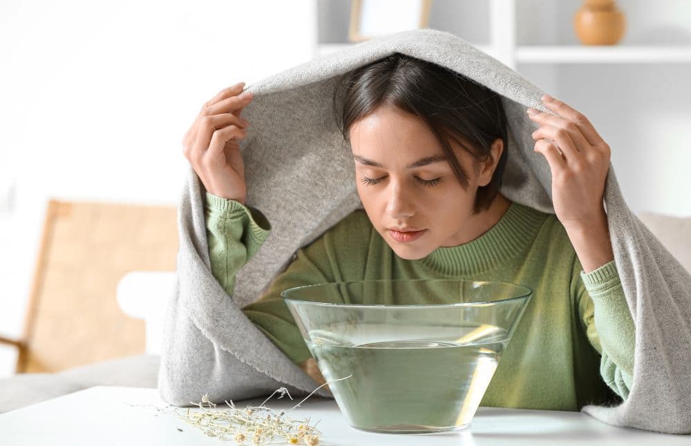 Kobieta wykonuje inhalacje parową Kobieta wykonuje inhalacje parową