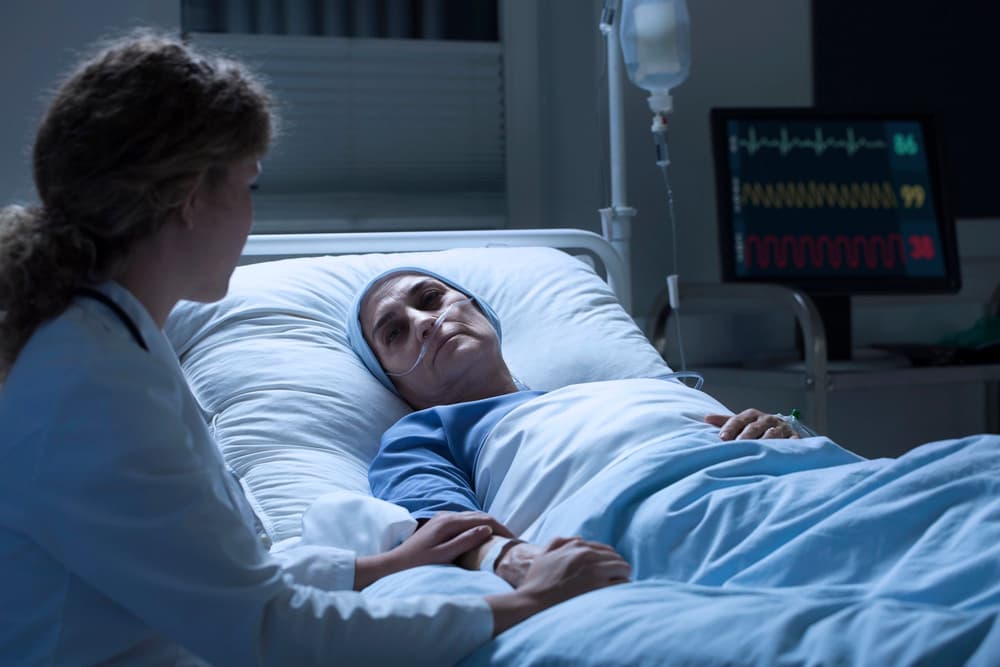 Kobieta na szpitalnym łóżku podczas leczenia paliatywnego. Kobieta na szpitalnym łóżku podczas leczenia paliatywnego.