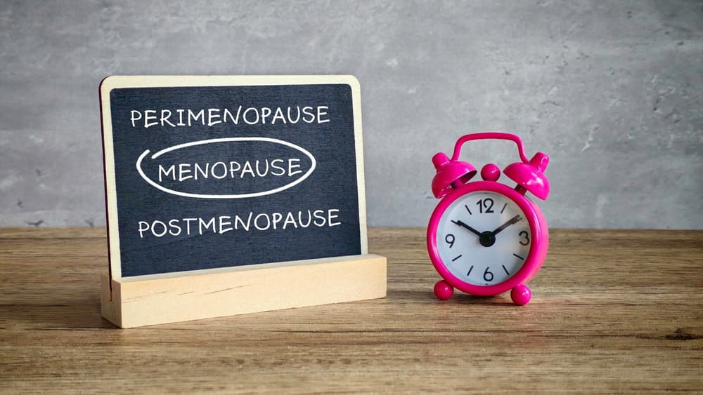 schemat cyklu menopauzy na tablicy obok budzika schemat cyklu menopauzy na tablicy obok budzika