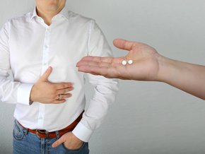 Mężczyzna cierpiący na zgagę i tabletki na zgagę