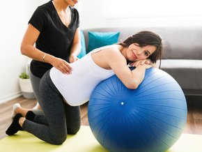 Kobieta w ciąży na piłce rehabilitacyjnej