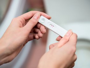Kobieta trzymająca test ciążowy.
