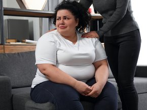 Płacząca kobieta doświadczająca fat shamingu.