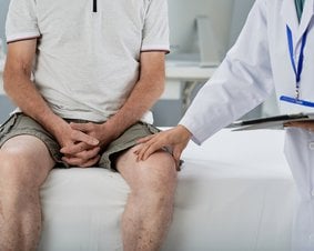 Lekarz badająca udo pacjenta.