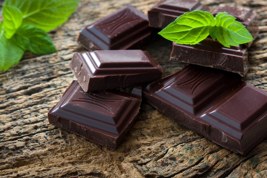 Kostki gorzkiej czekolady ozdobione listkami mięty.