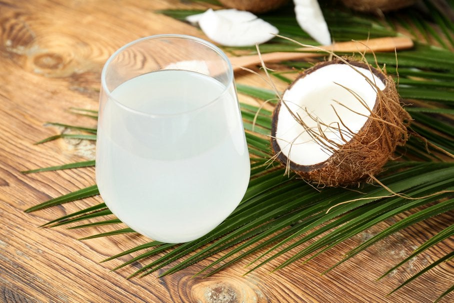 Szklanka wody kokosowej i orzech kokosowy.