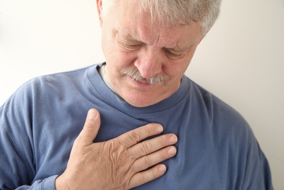 Starszy mężczyzna odczuwający ból w klatce piersiowej.