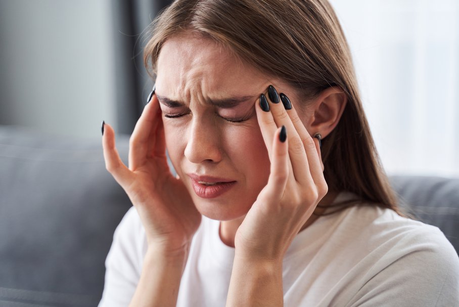 Młoda kobieta cierpiąca na napięciowy ból głowy.