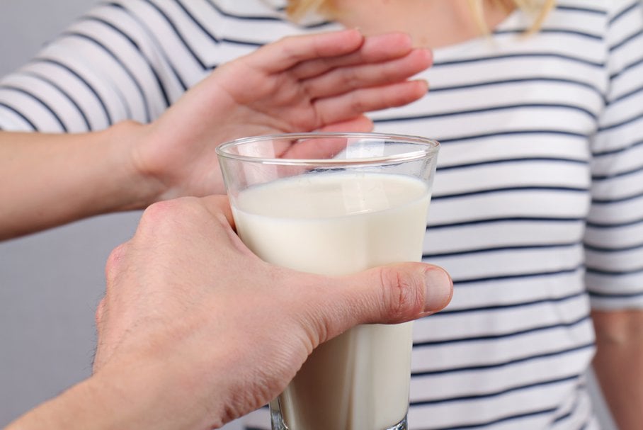 Kobieta odmawiająca szklanki mleka.
