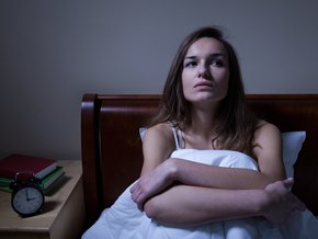 Młoda kobieta w łóżku nie może zasnąć.