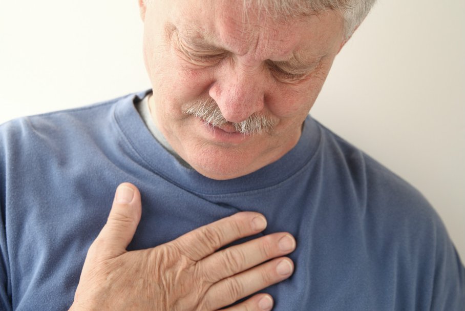 Starszy mężczyzna odczuwający ból w klatce piersiowej.