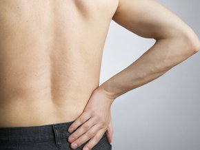 Mężczyzna trzymający się za biodro.