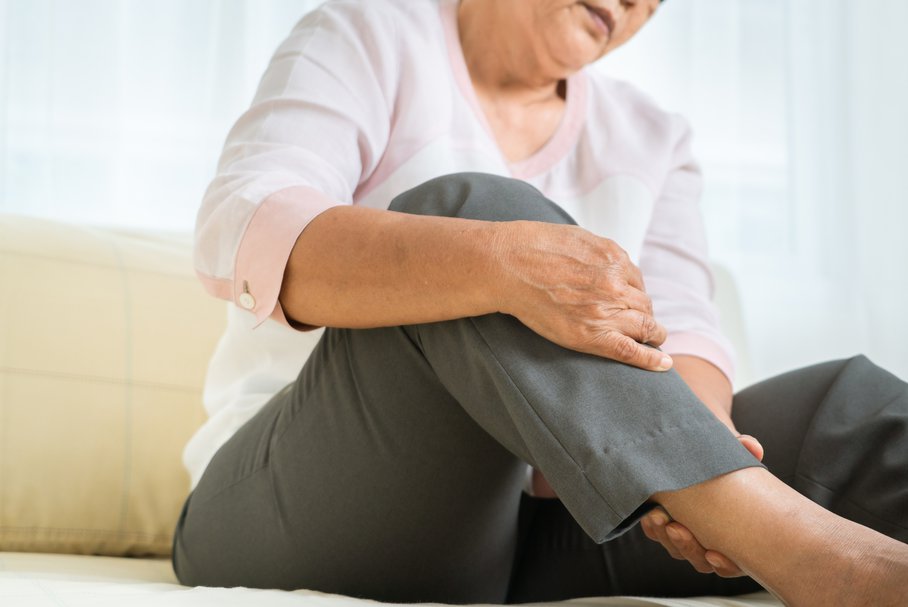 Starsza kobieta odczuwająca ból nóg.